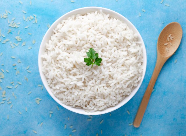 arroz branco em uma tigela com colher de pau