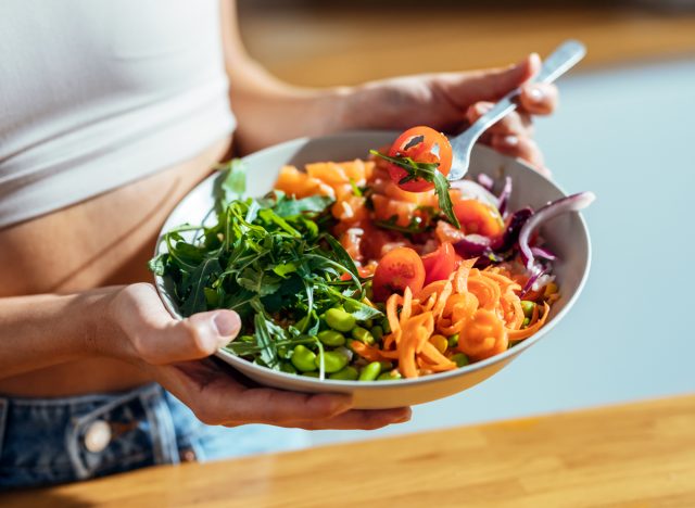 mulher comendo vegetais grande e saudável salada de carboidratos