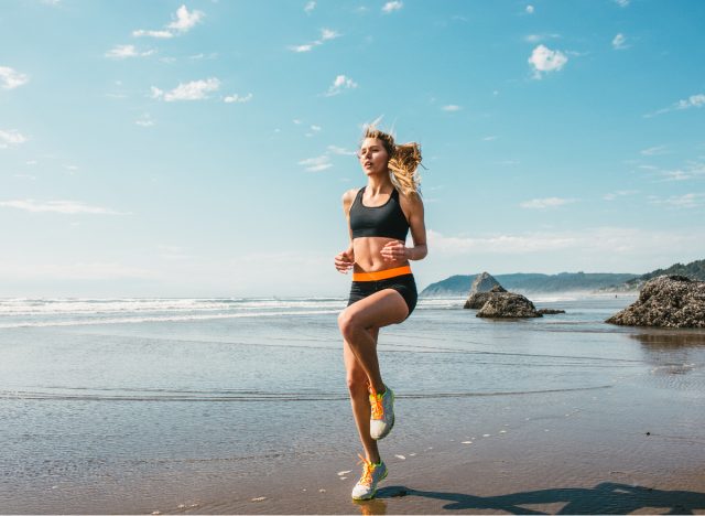 mulher fazendo exercícios HIIT na praia, conceito de exercícios para derreter gordura do estômago